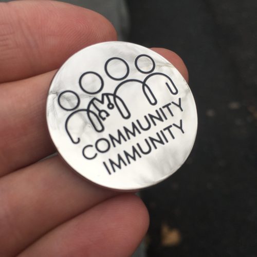 Community Immunity Badge Pin in hand 3